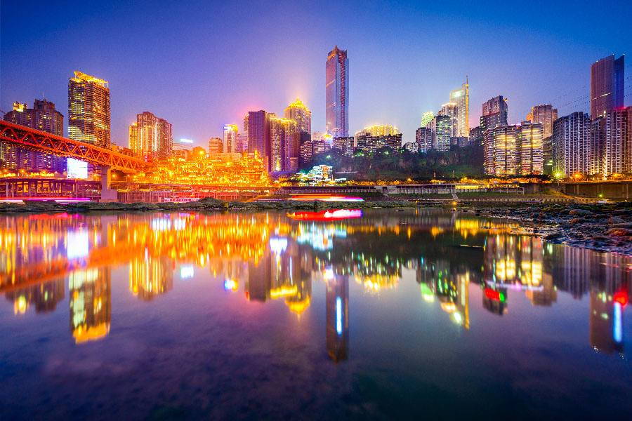 Anochecer en Chongqing con agua efecto espejo de la ciudad con luces brillantes.