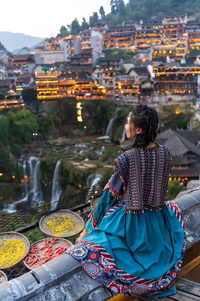 Mujer contemplando desde lo alto la ciudad de Lijiang.